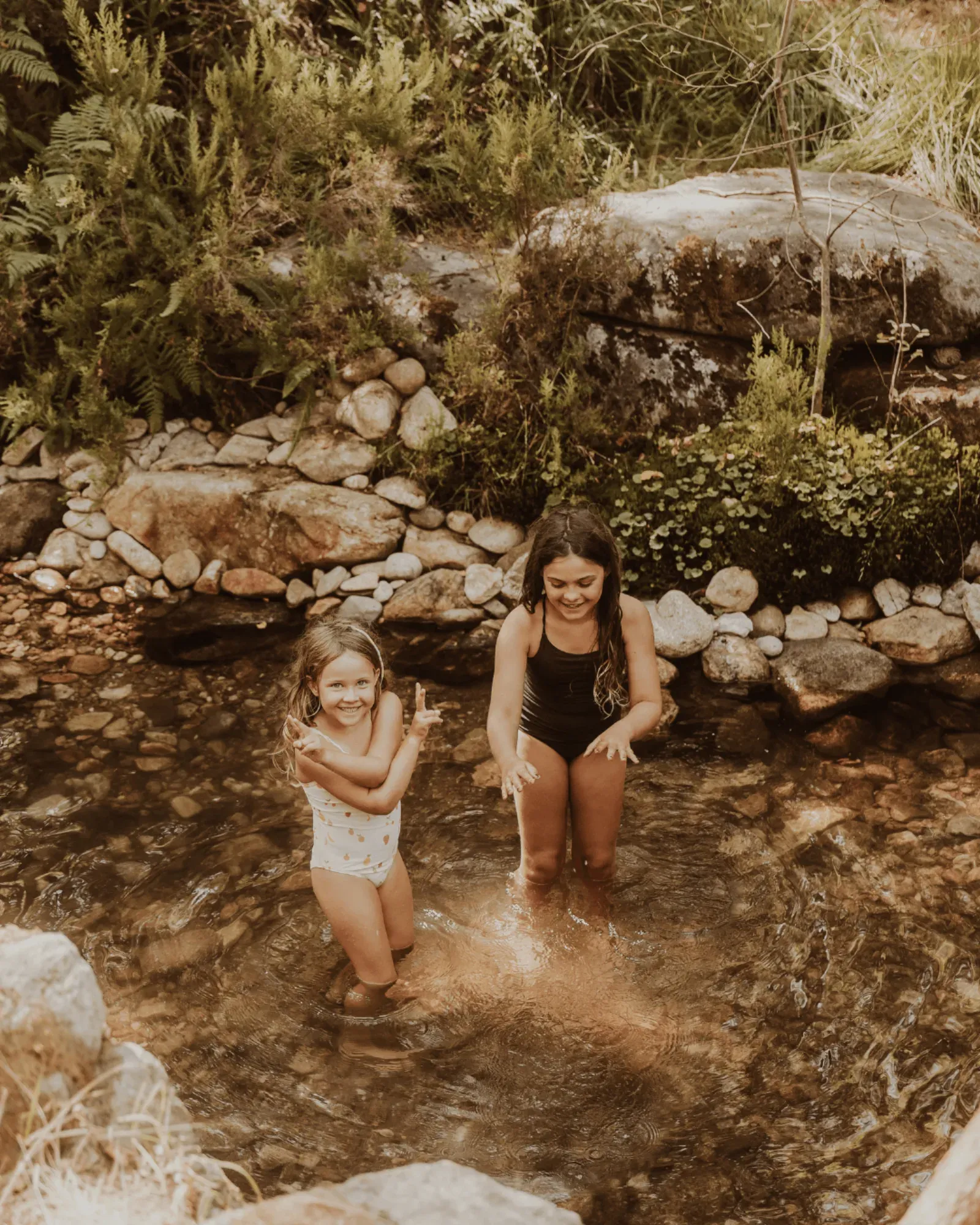 A mother and child paddling in a rock pool