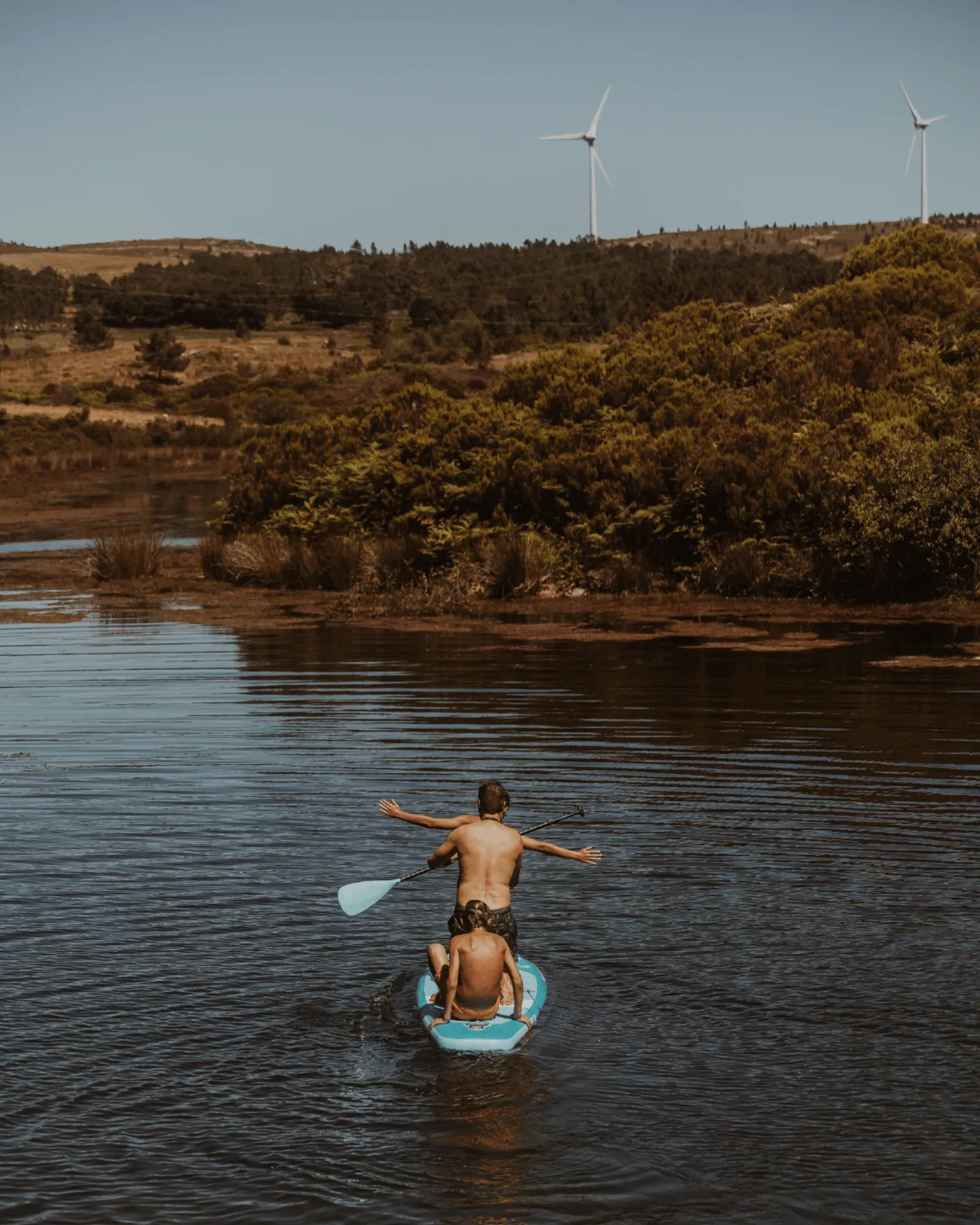 A parent and child on a paddleboard on the river